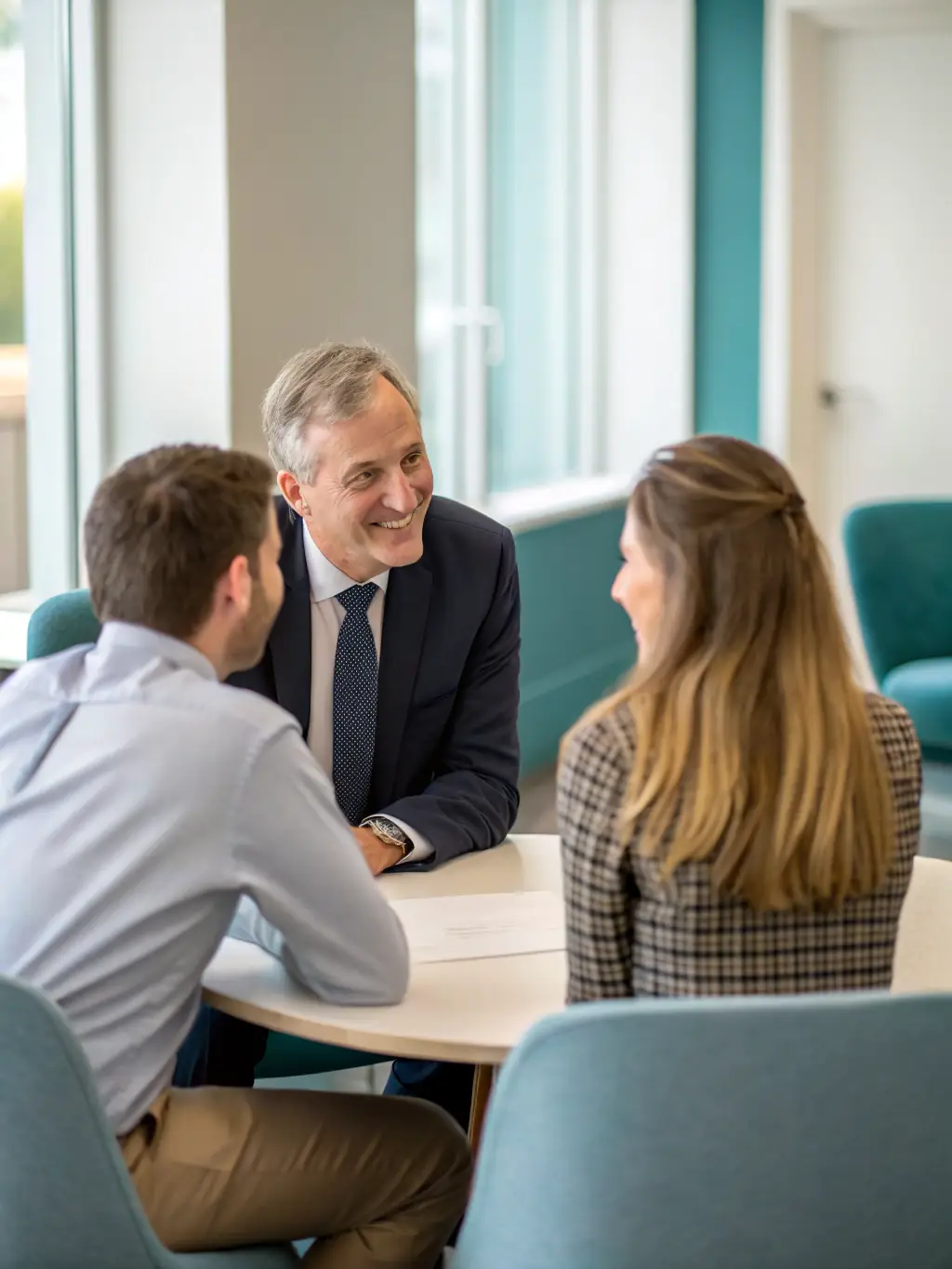 A professional mediator facilitating a face-to-face discussion between two business professionals in a modern conference room, representing in-person bilateral mediation.